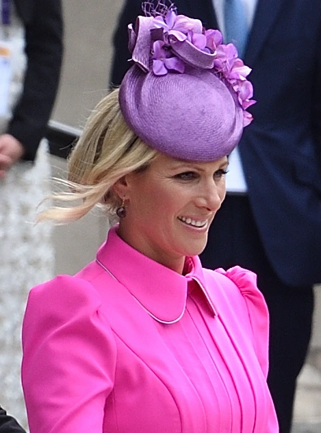 Zara Tindall in a bright pink outfit and purple hat at a royal event