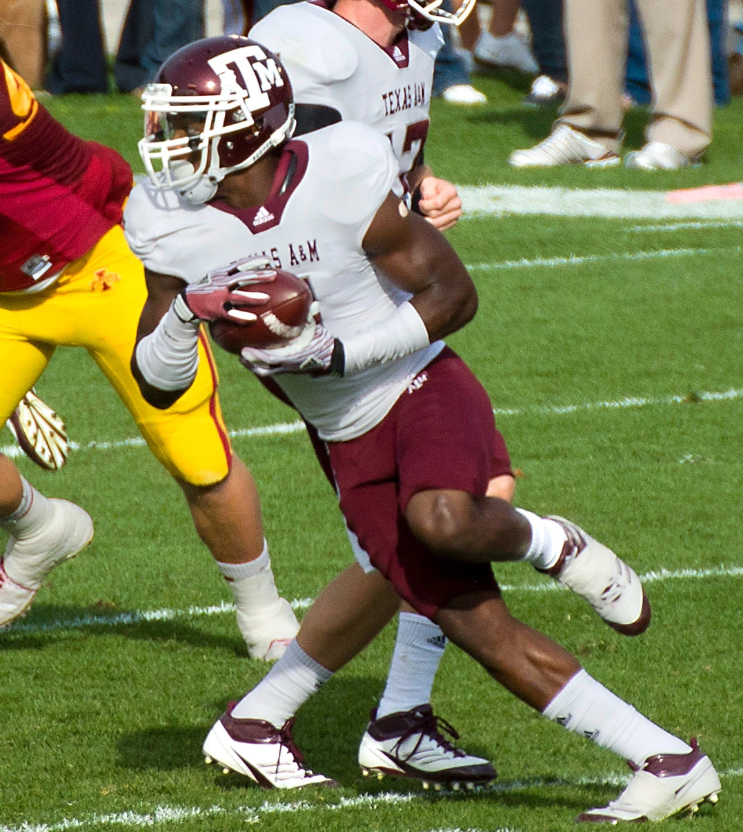 Uzoma Nwachukwu in action during an American football game, carrying the ball in a Texas A&M uniform